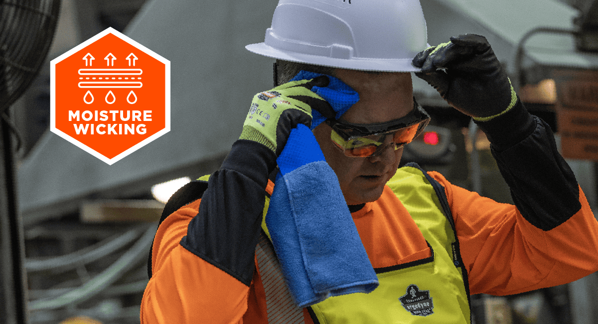 Worker wearing a moisture-wicking bandana while putting on a hard hat