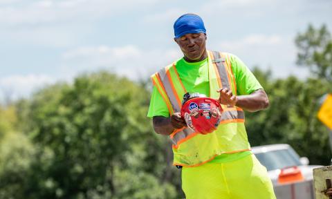 Worker outside looking down at red hard hat