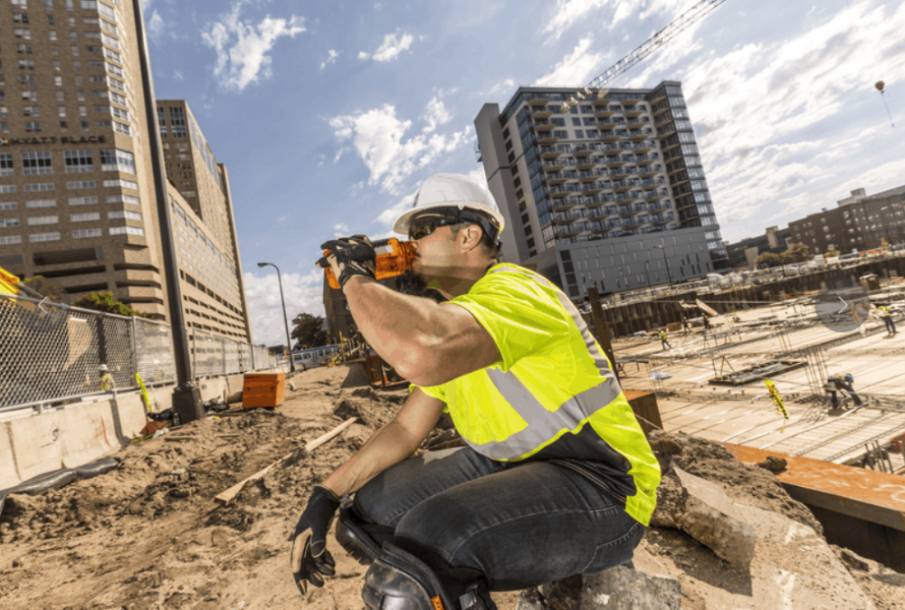 Worker getting hydrated in hi vis gear