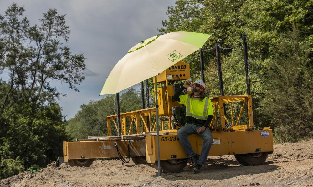 Worker drinking water under tent