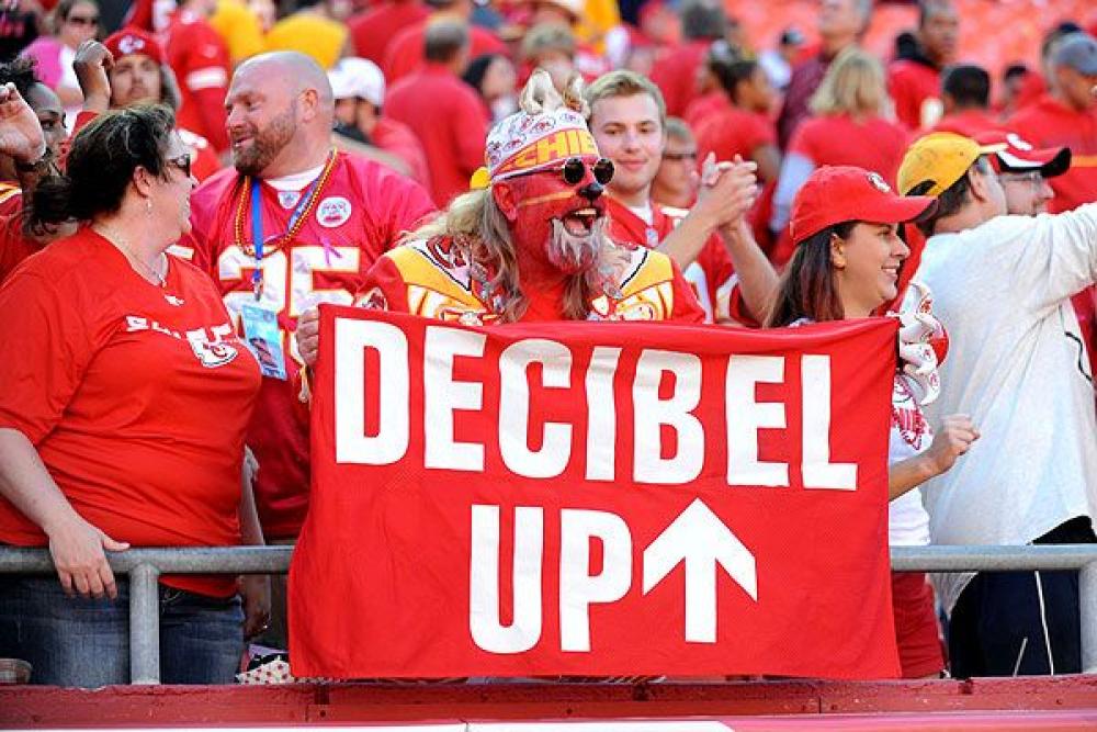 kansas city chiefs game. man holding a decibel up sign.