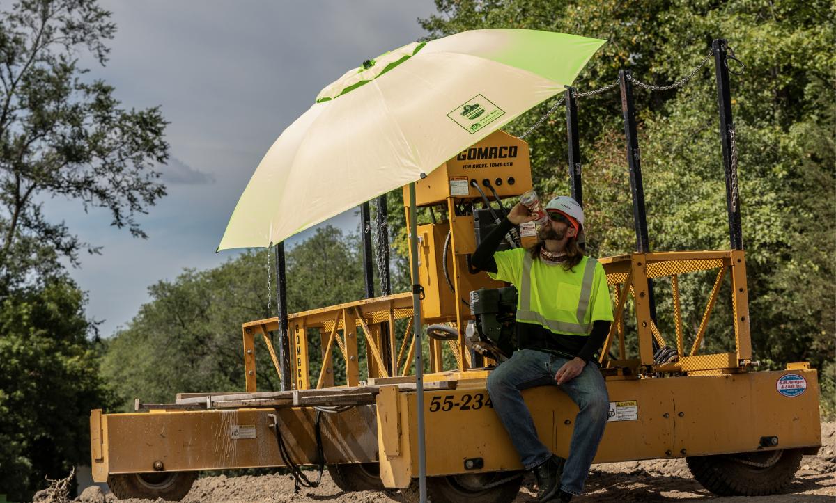 Worker resting under umbrella