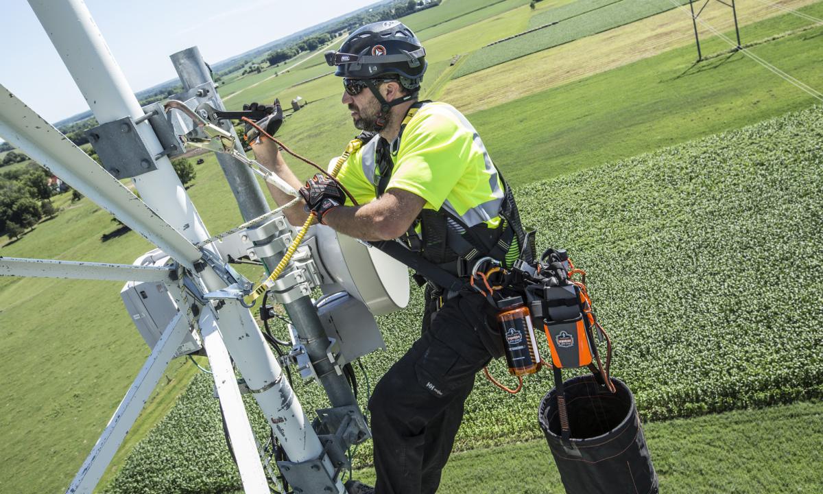 Worker climbing tower with hoist bucket