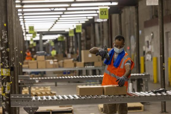 man wearing cooling towel and hi-vis vest working in a warehouse